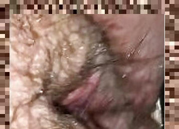 Slut rubs her wet hairy pussy in a public shower