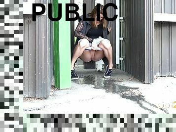 Scantily clad girl peeing in public