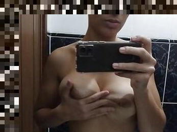 Hot brunette exhibitionist banging her tits in the mirror