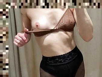 Girl in black pantyhose is trying on new bras. Fitting room video