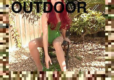 Fetish model with red hair Poison Ivy posing outdoors