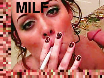 Horny brunette giving head while smoking a cigarette