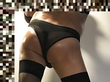 Crossdresser dressed up for seduce. Oiled body with thong and pantyhose.