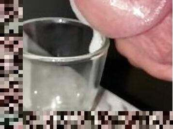 Squeezing milky cum out of the tip of my dick, shot glass collecting for cumplay, closeup